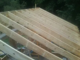 New roof rafters set over an addition before sheathing in Huntington