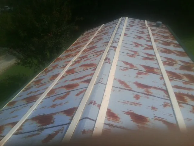 Rusted metal roof panels with new wood purlins before replacement — Storm Damage Roof Repair in Huntington by Roofing Brothers
