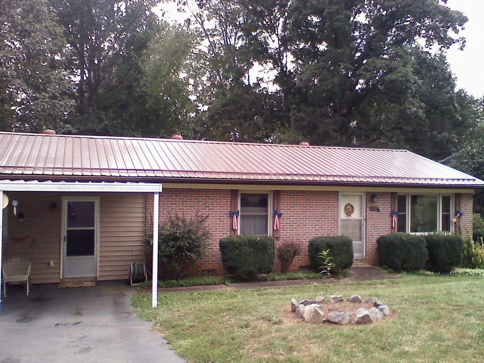 Bronze metal roof and carport on a brick ranch home — Roof Repair work by our crew in Huntington